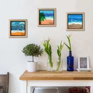 Palm Tree Beach, a painting by Aria Luna, framed and displayed in a small home office