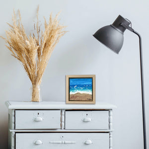 Shifting Dunes Beach, a painting by Aria Luna, framed and displayed on a bedroom dresser