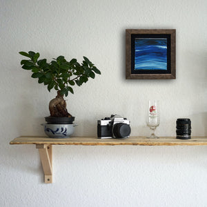 Waves of Thunder, a painting by Aria Luna, framed and displayed above a living room shelf